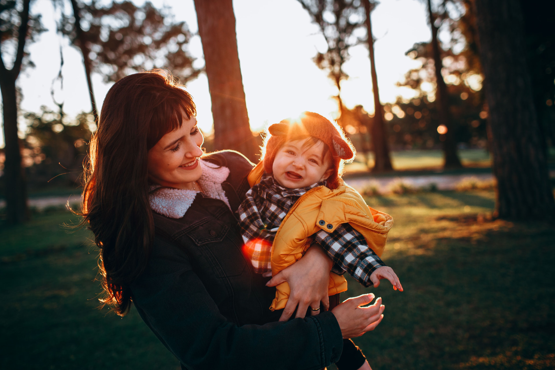 A mother holding her baby outdoors